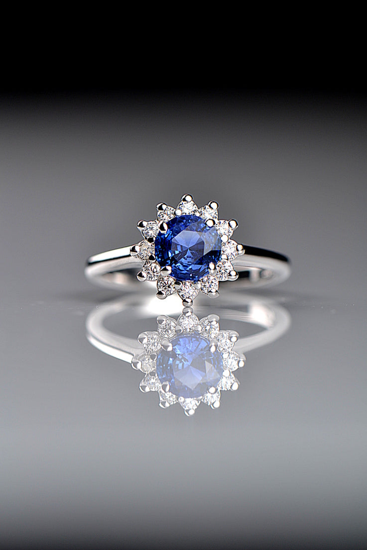 handmade platinum sapphire and diamond engagement ring in a flower shape on a grey background - Christine Sadler