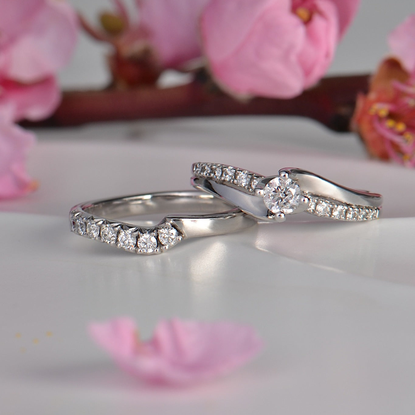 white gold shaped wedding ring with diamonds beside the engagement ring that it was made to match