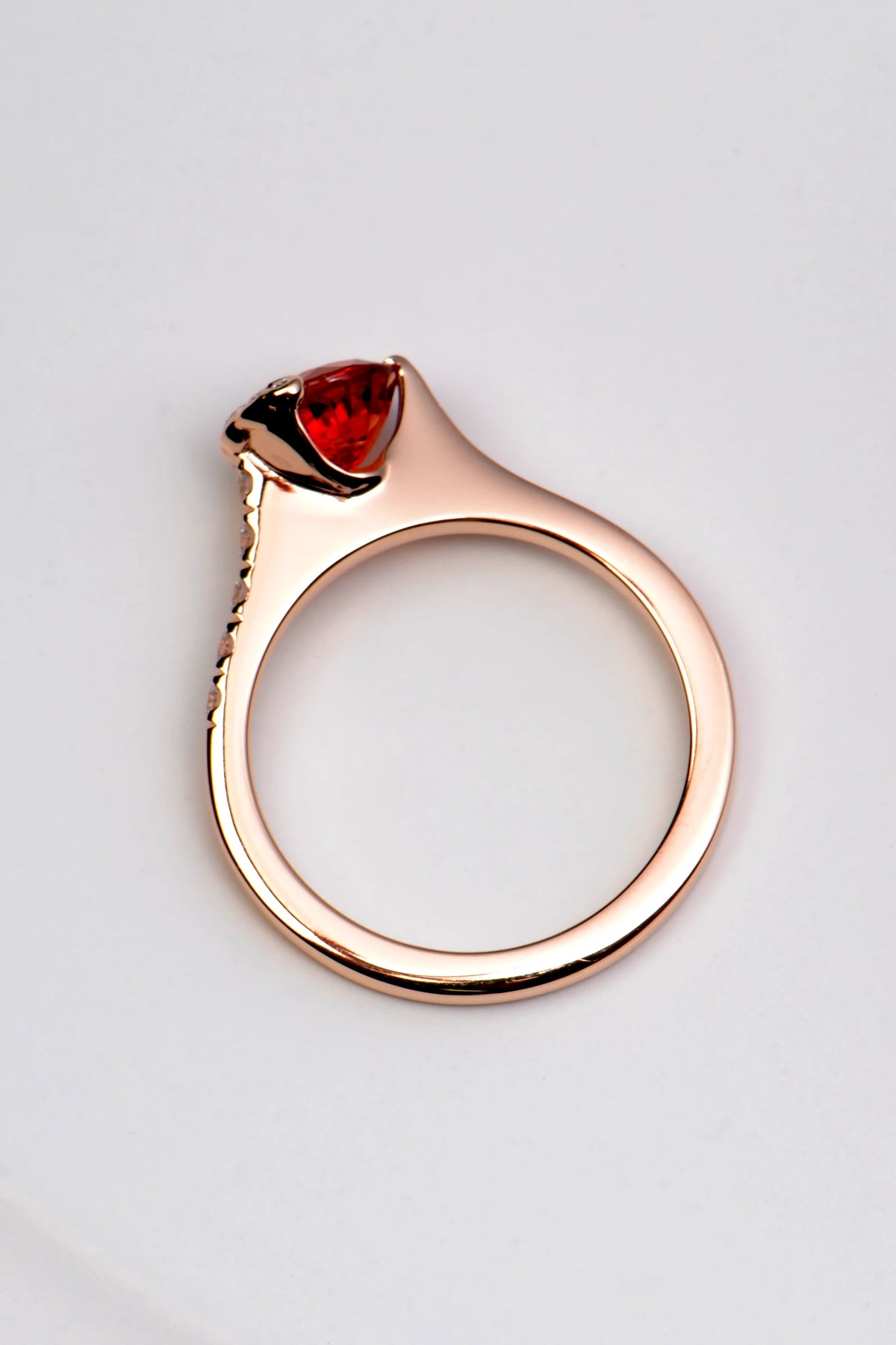 Profile of orange sapphire ring in 18ct rose gold, showing the raised setting and diamond band detail