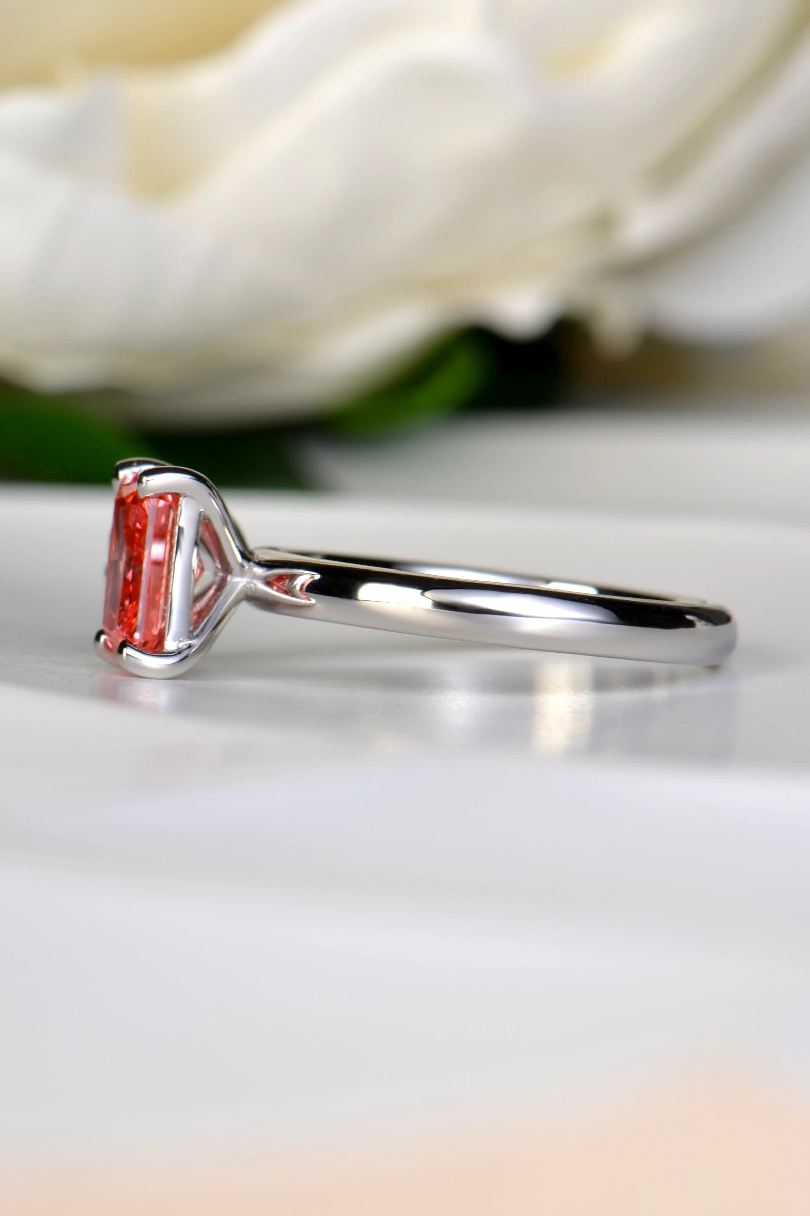 Side profile view of a platinum Moi et Toi ring highlighting the claw setting of the 1.29 carat radiant cut fancy vivid pink lab diamond, by Christine Sadler.
