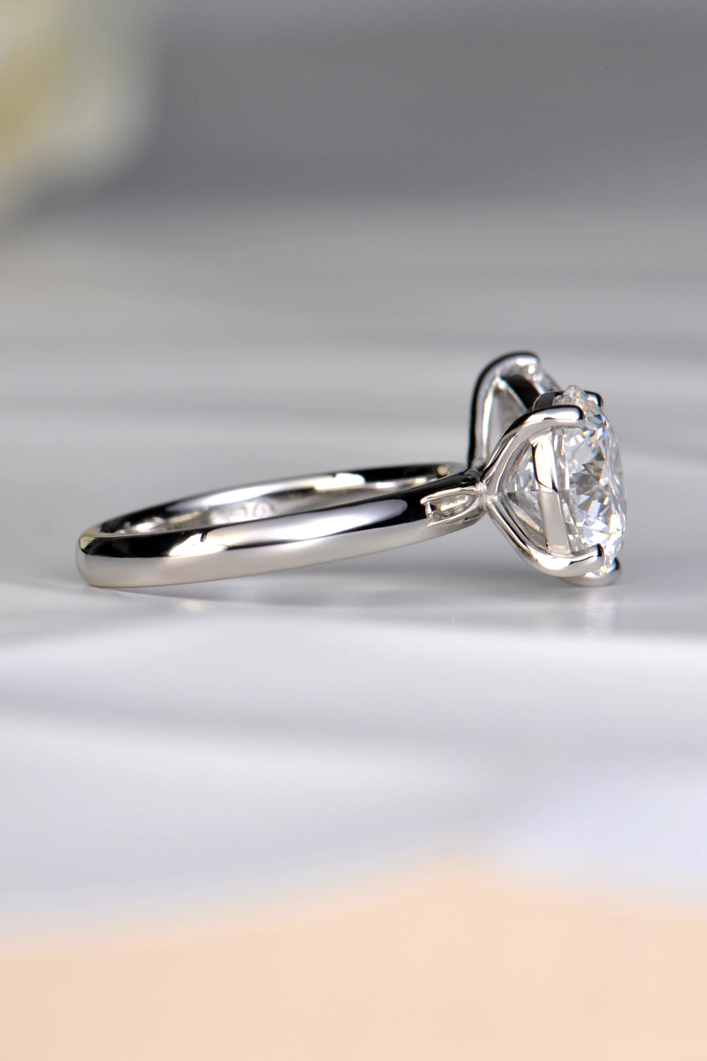 Side profile view of a 3.05ct round brilliant lab diamond in a raised platinum setting showing how a wedding band fits flush by Christine Sadler