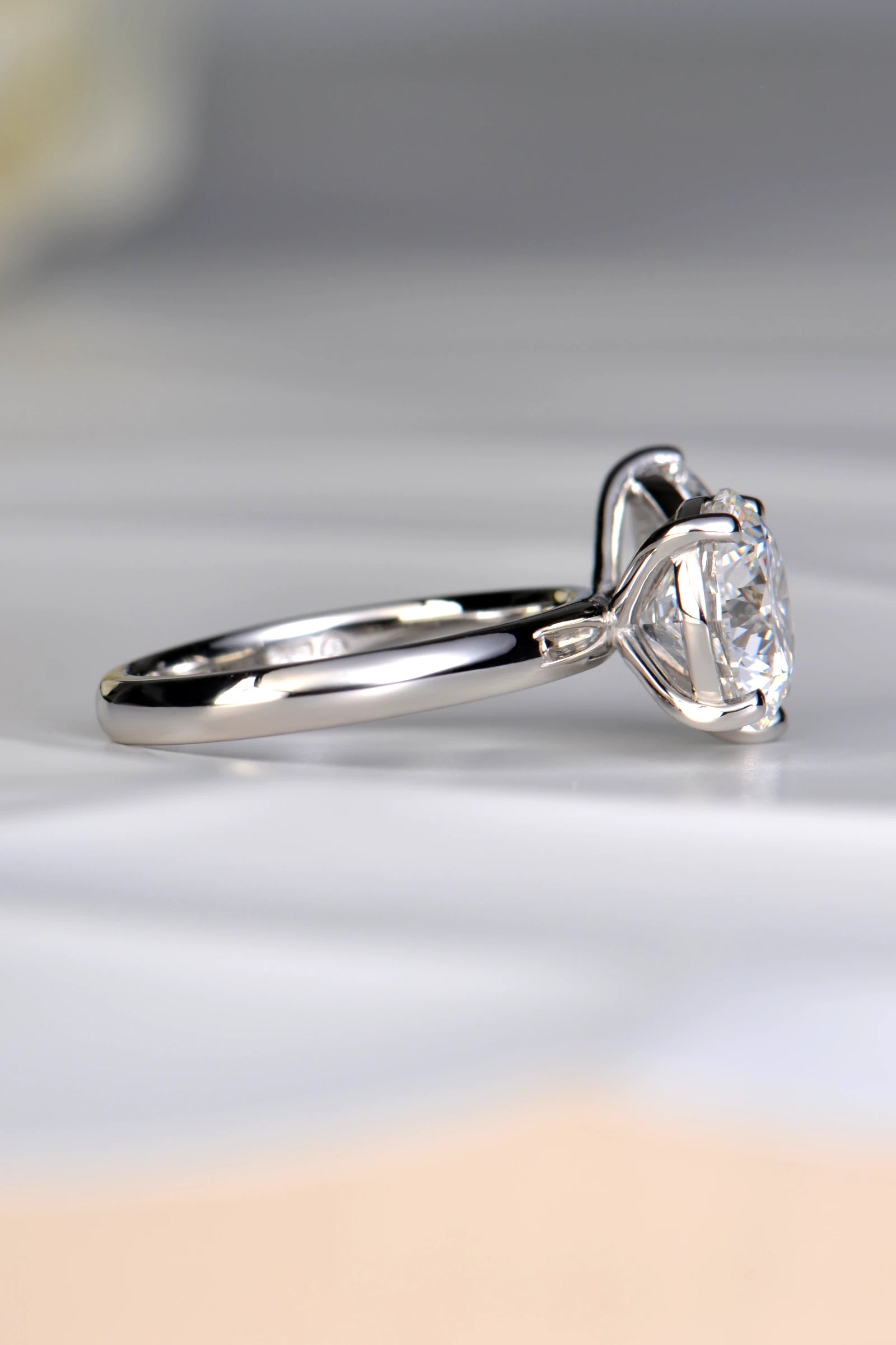 Side profile view of a 3.05ct round brilliant lab diamond in a raised platinum setting showing how a wedding band fits flush by Christine Sadler