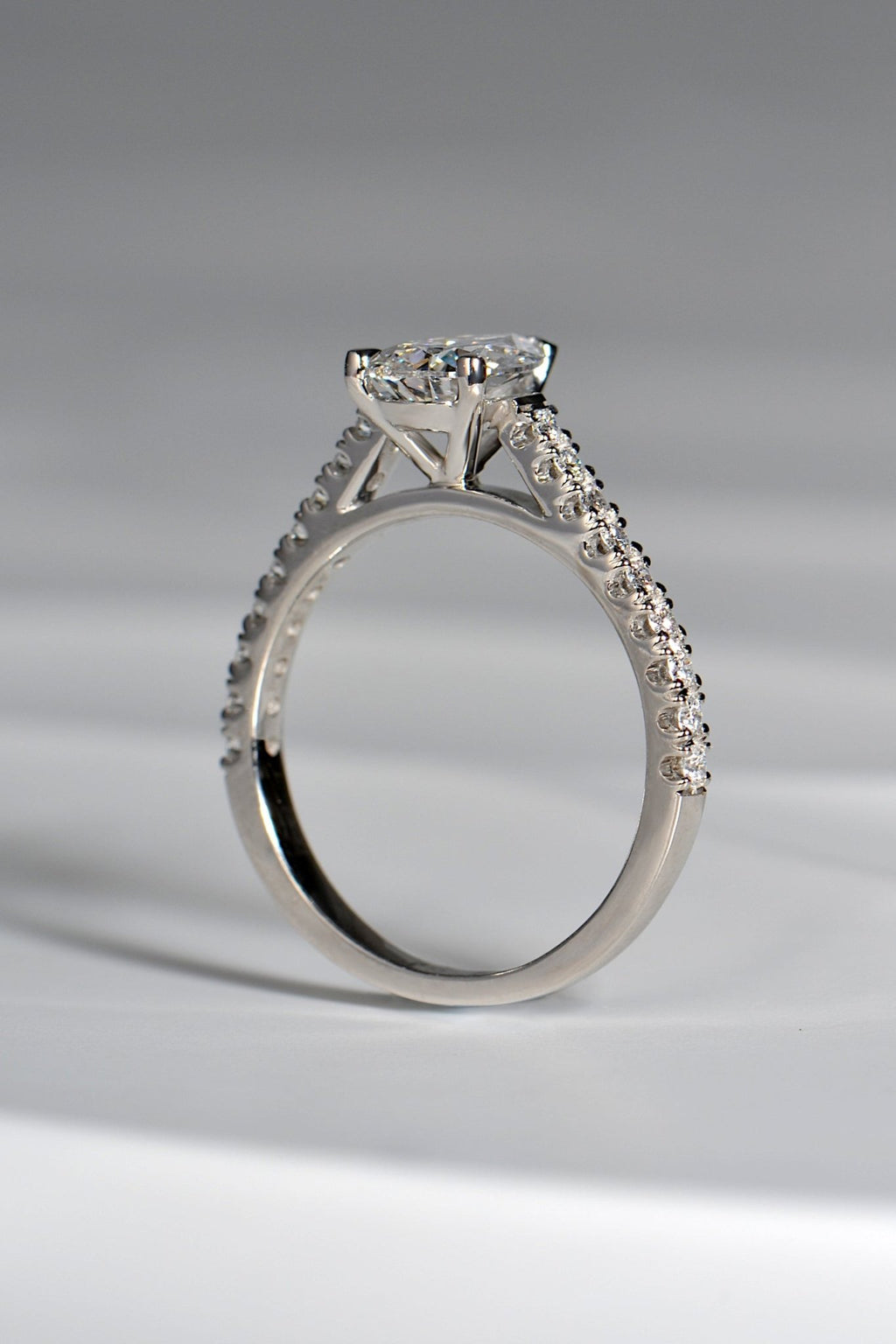 snuggle fit pear cut diamond engagement ring in platinum with diamonds in the shoulders