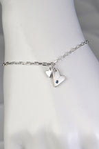 Sterling silver two‑heart bracelet with aquamarine displayed on white mannequin wrist to show size and scale from the From The Heart collection by Christine Sadler