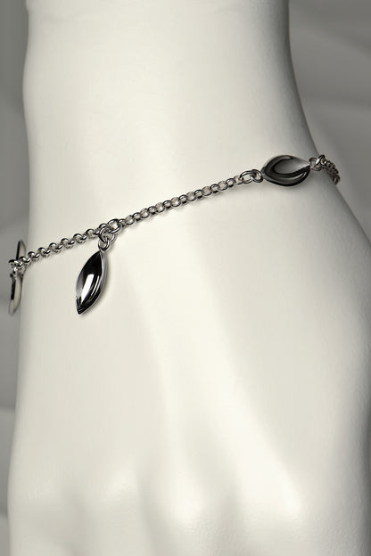 modern silver charm bracelet with concave seed shapes. For each bracelet sold, a tree is planted - Christine Sadler