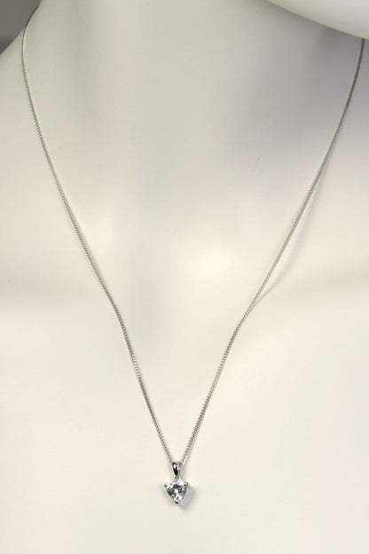 Silver necklace with a heart-shaped pendant on a mannequin.