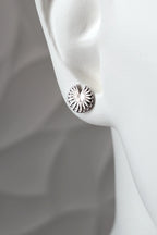 Sterling silver Break the Wheel talisman round stud earring shown on a mannequin ear to show size and scale
