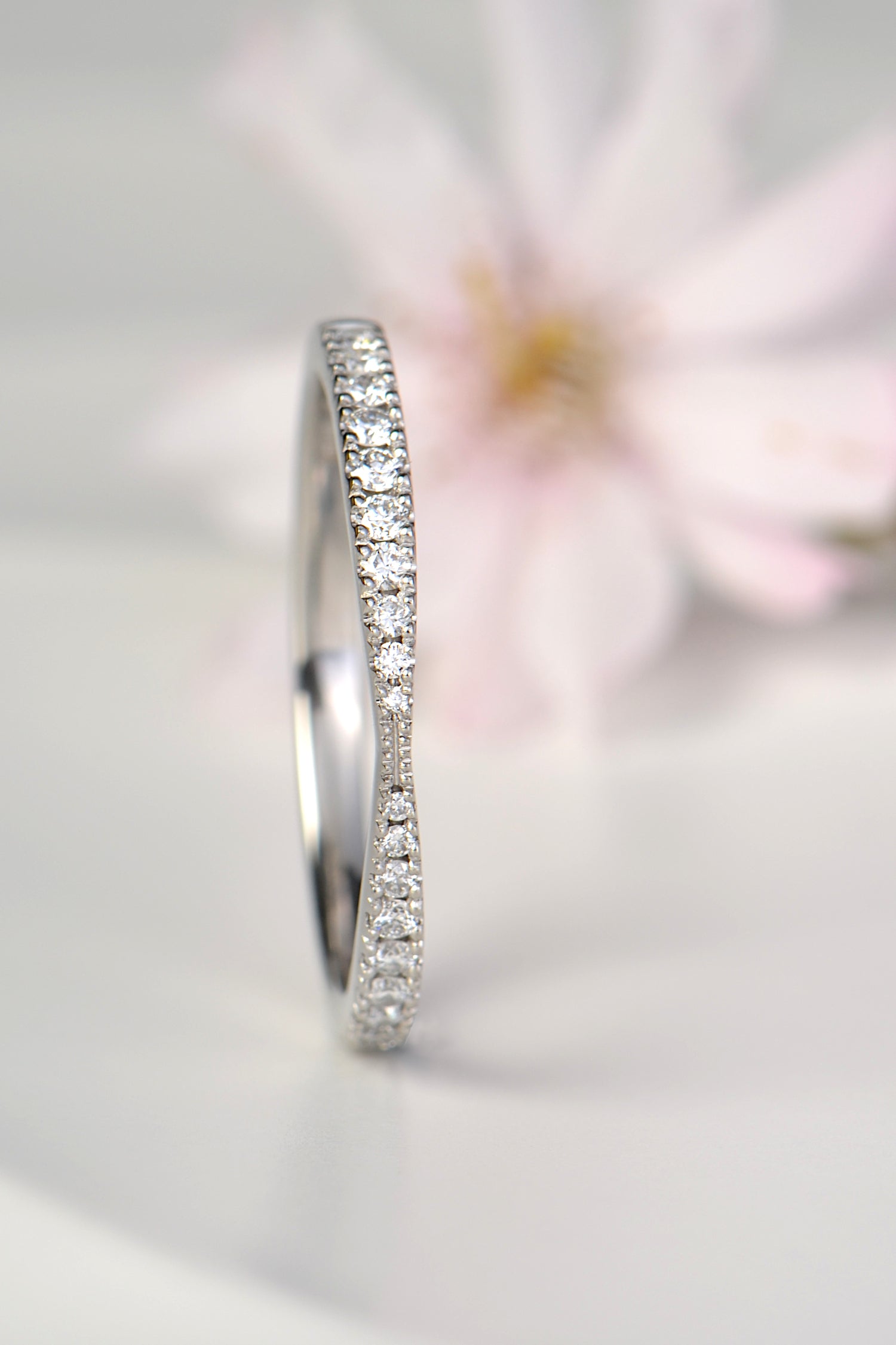 gorgeous platinum skinny diamond wedding ring that is pinched in the middle