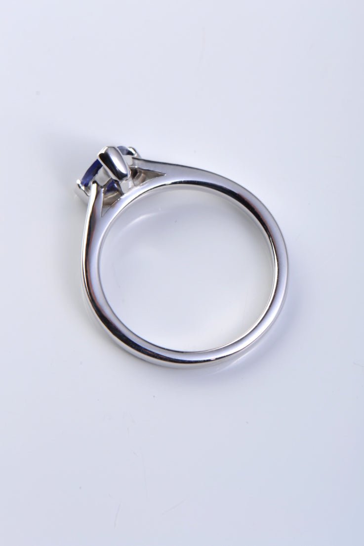 The triangular tanzanite is held by a single claw opposite the rubbed over setting of the gemstone in this modern designer ring