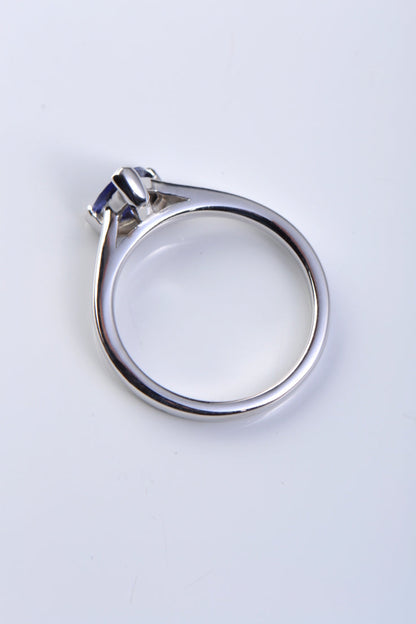 The triangular tanzanite is held by a single claw opposite the rubbed over setting of the gemstone in this designer ring