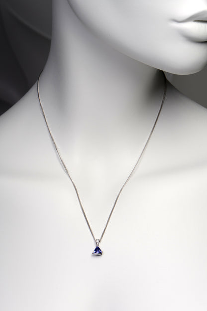 handmade high quality tanzanite and diamond designer necklace shown on a model. The pendant hangs about two inches below the collar bones