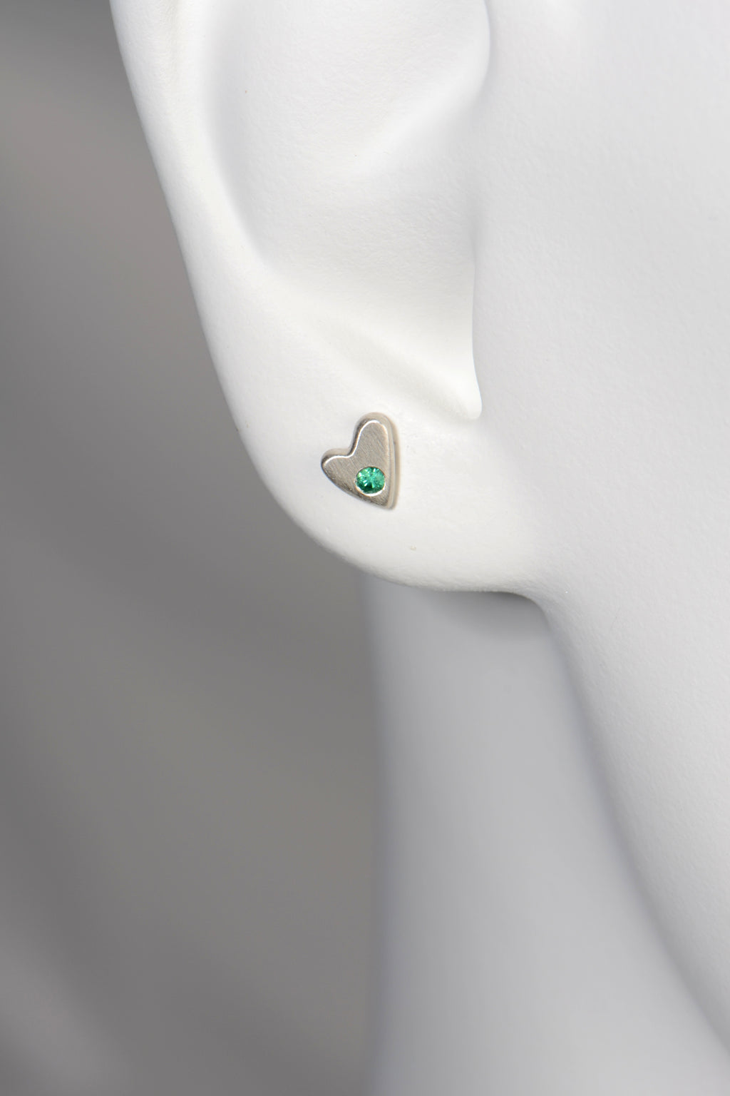 Silver Emerald heart earrings shown on a white mannequin to show size and scale