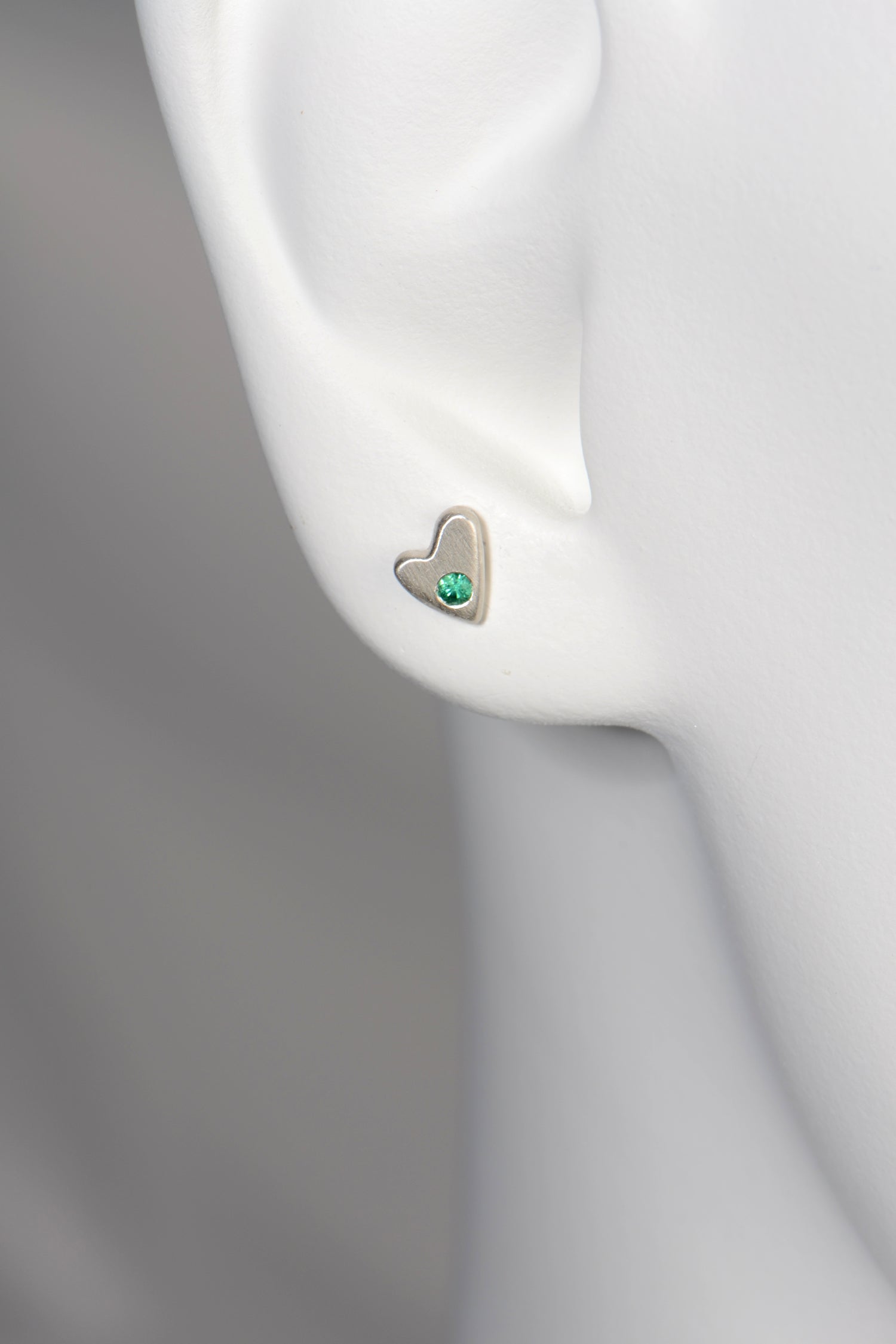 Silver Emerald heart earrings shown on a white mannequin to show size and scale