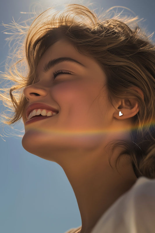 petite handmade silver stud earrings in a model's ear to show size and scale