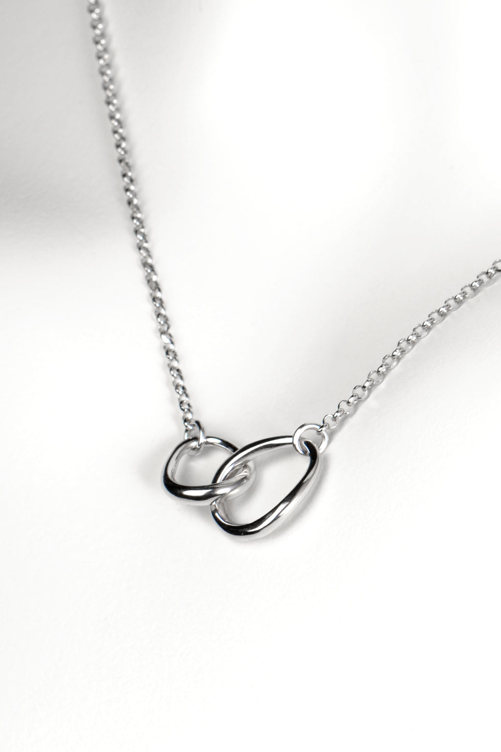 modern interlocking silver circle necklace with two links, one larger and one smaller, joined at the front on a fine silver chain