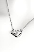 modern interlocking silver circle necklace with two links, one larger and one smaller, joined at the front on a fine silver chain