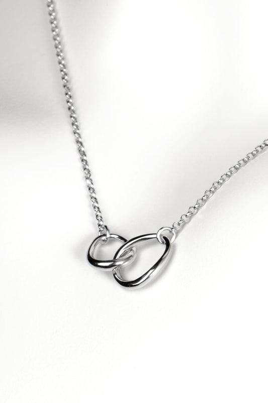 modern interlocking silver circle necklace with two links, one larger and one smaller, joined at the front on a fine silver chain