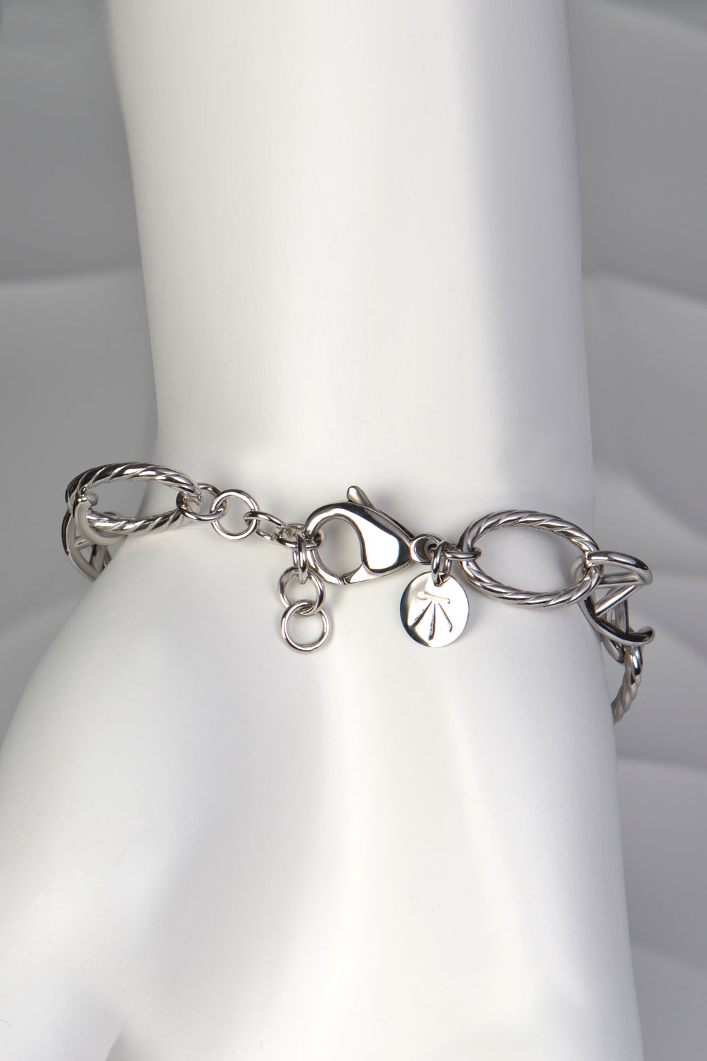 Silver Designer Genes bracelet displayed on a white mannequin hand, showing elegant scale and fit with adjustable clasp