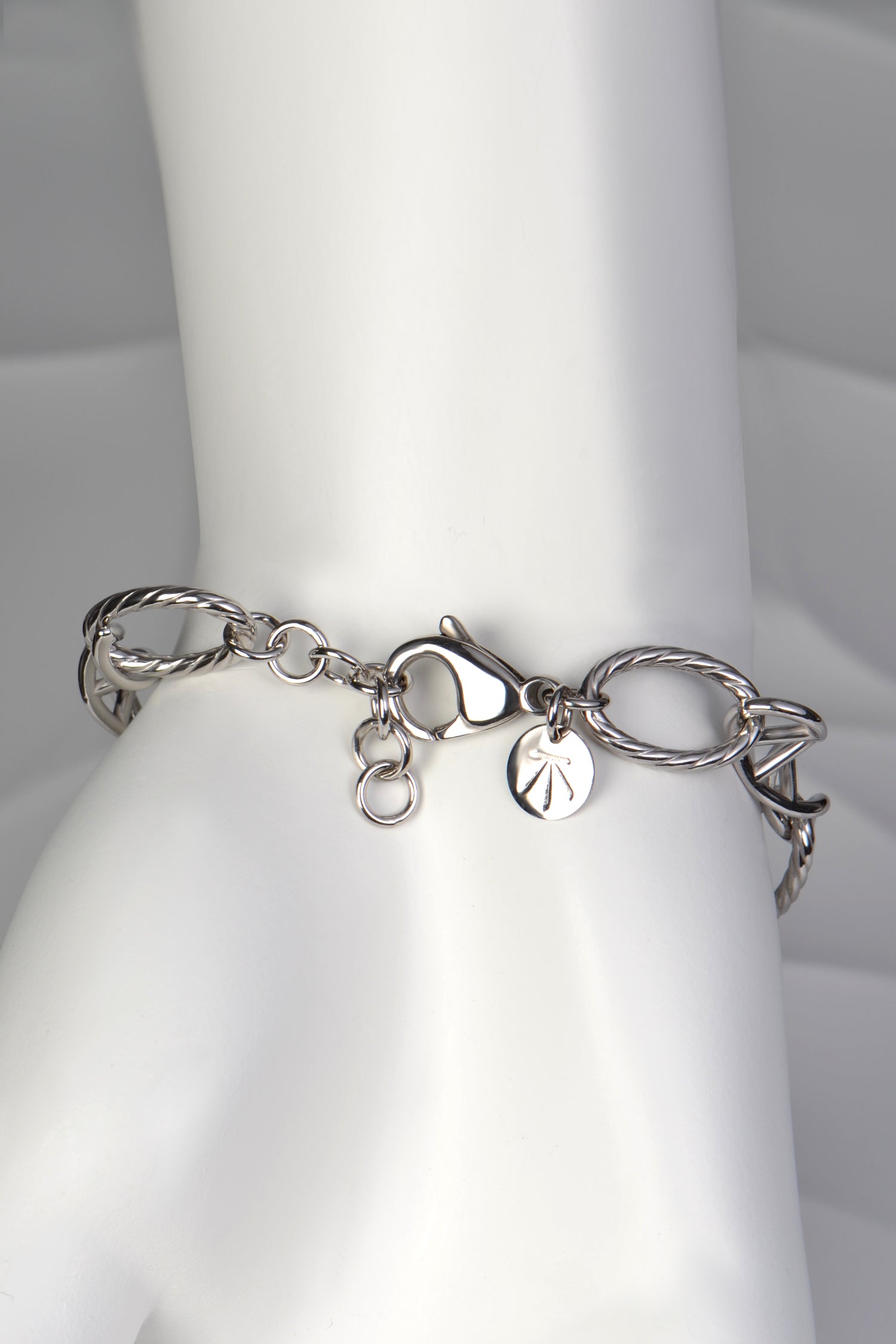 Silver Designer Genes bracelet displayed on a white mannequin hand, showing elegant scale and fit with adjustable clasp