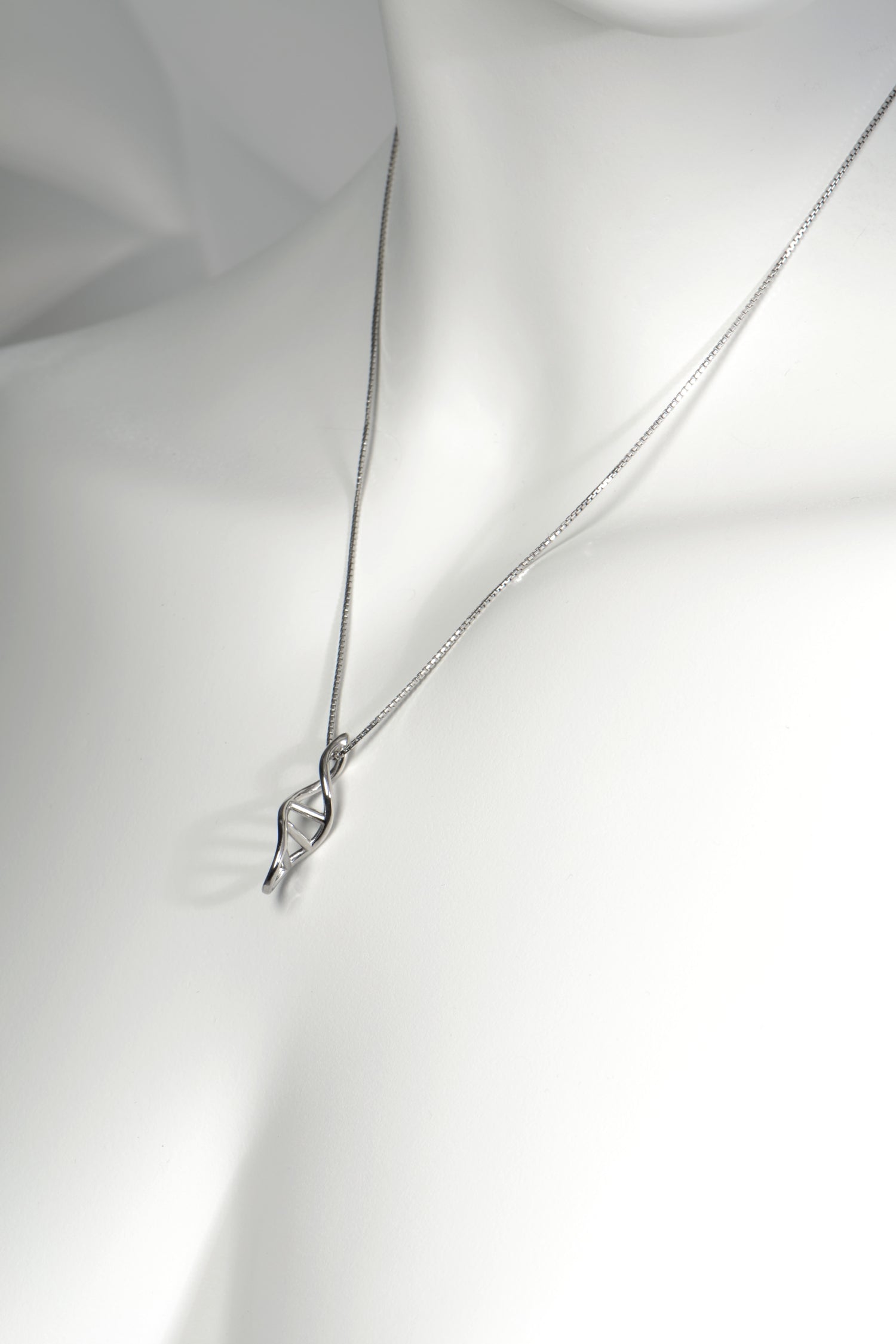 White mannequin showcasing the silver dna helix necklace to illustrate length and fit - Christine Sadler