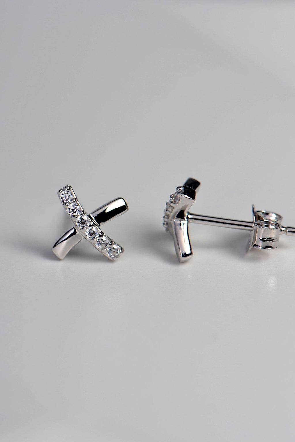 sterling silver stud earrings in a cross shape like a kiss with sparkling cubic zirconias