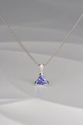 modern white gold necklace with three diamonds and a triangular tanzanite hanging below them by jewellery designer Christine Sadler