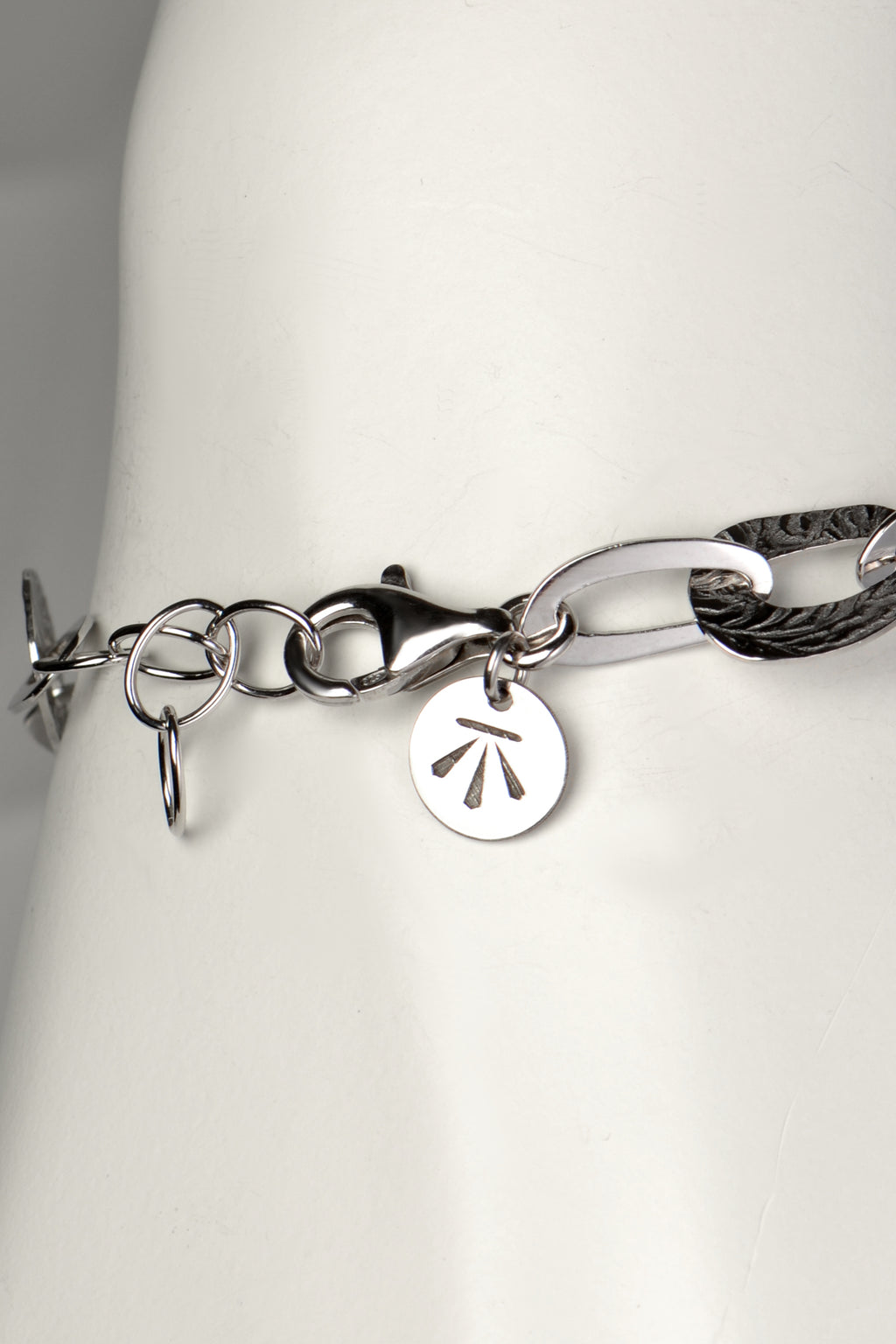 adjustable silver bracelet that an be made larger or smaller with Christine Sadler's benchmark branded logo tag at the clasp