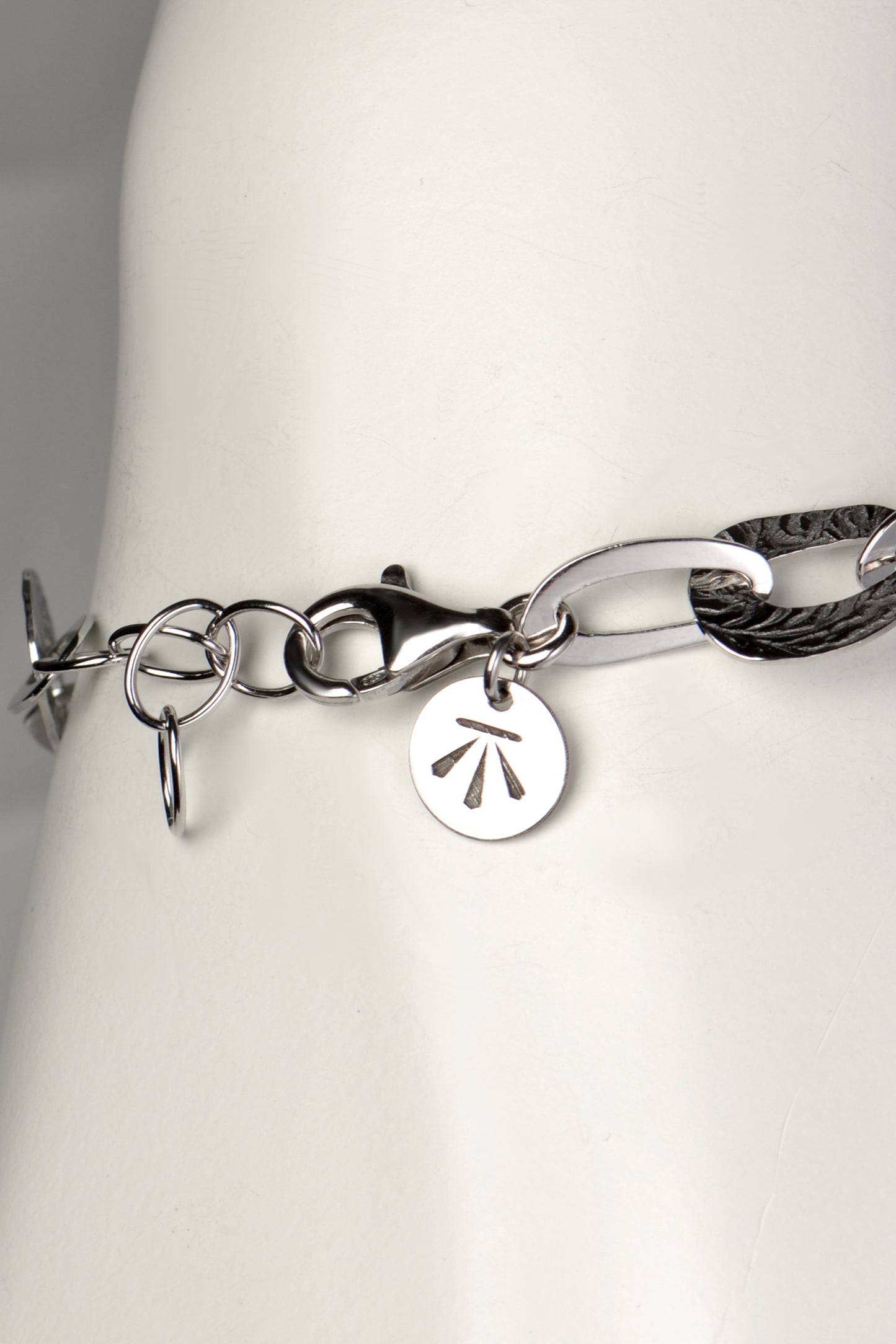 adjustable silver bracelet that an be made larger or smaller with Christine Sadler's benchmark branded logo tag at the clasp
