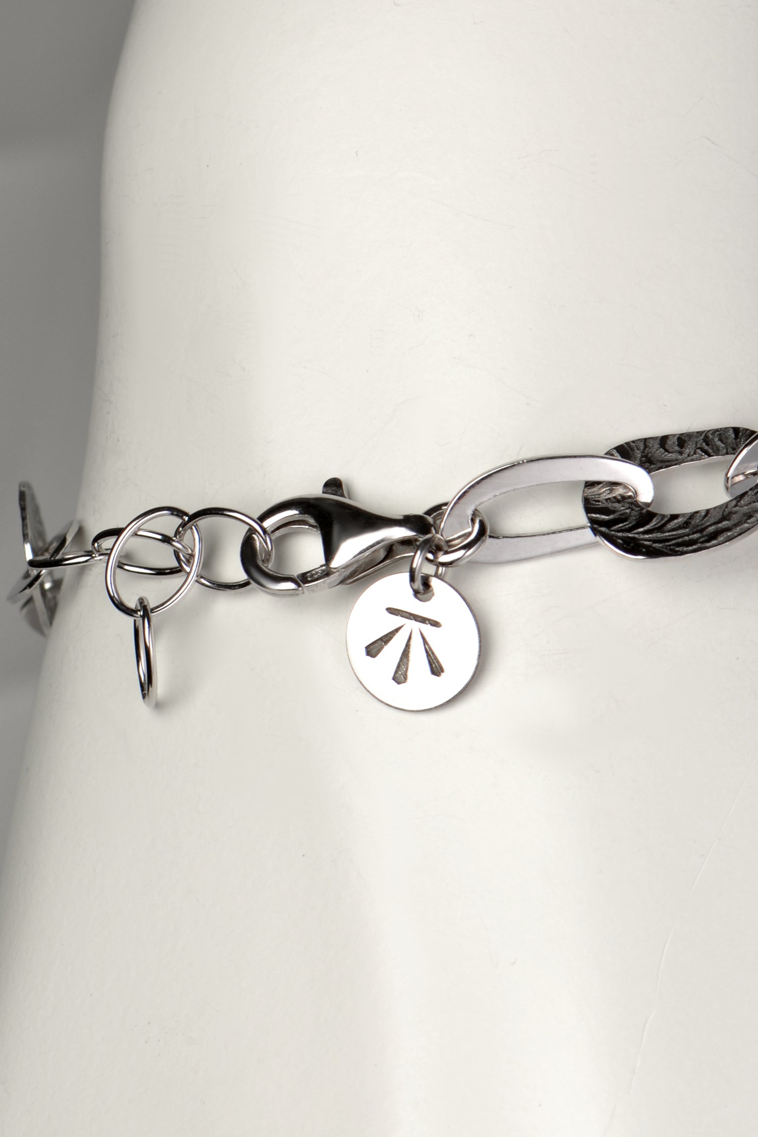 adjustable silver bracelet that an be made larger or smaller with Christine Sadler's benchmark branded logo tag at the clasp