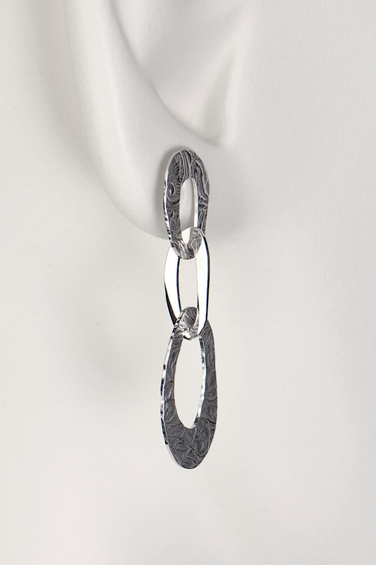 three interlocking organic oval links form a long drop silver earring with a textured pattern on the links inspired by the natural beauty of frost patterns - Christine Sadler