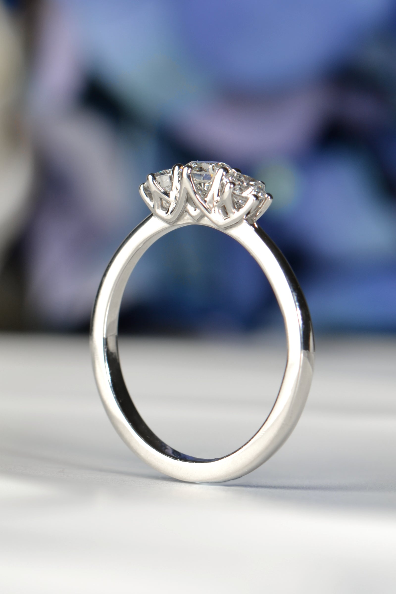 Close-up of round brilliant diamonds in six-claw platinum setting with cathedral-style sweeping arches