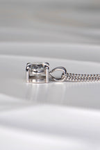Side view of a white gold diamond pendant showing the double bail design, talon claws, and low-profile basket setting. Christine Sadler