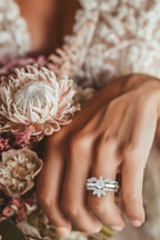 Bride showing off her engagement ring with a five petal platinum wedding guard ring on either side - Christine Sadler