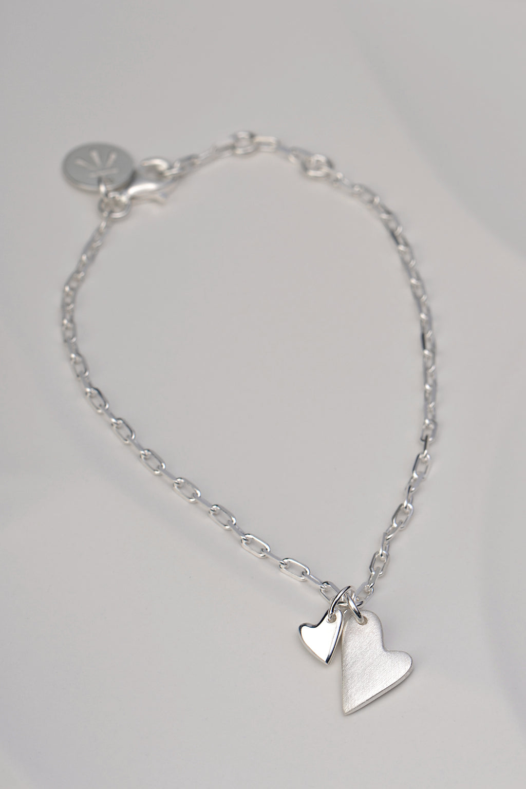Sterling silver bracelet with two heart charms – one brushed, one polished – symbolising emotional connection from the From The Heart collection by Christine Sadler