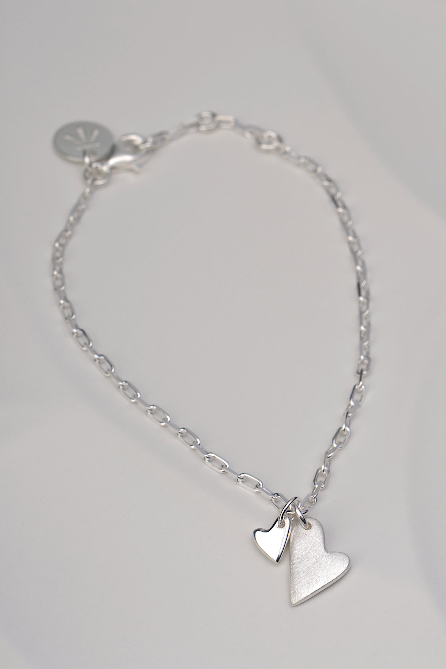 Sterling silver bracelet with two heart charms – one brushed, one polished – symbolising emotional connection from the From The Heart collection by Christine Sadler