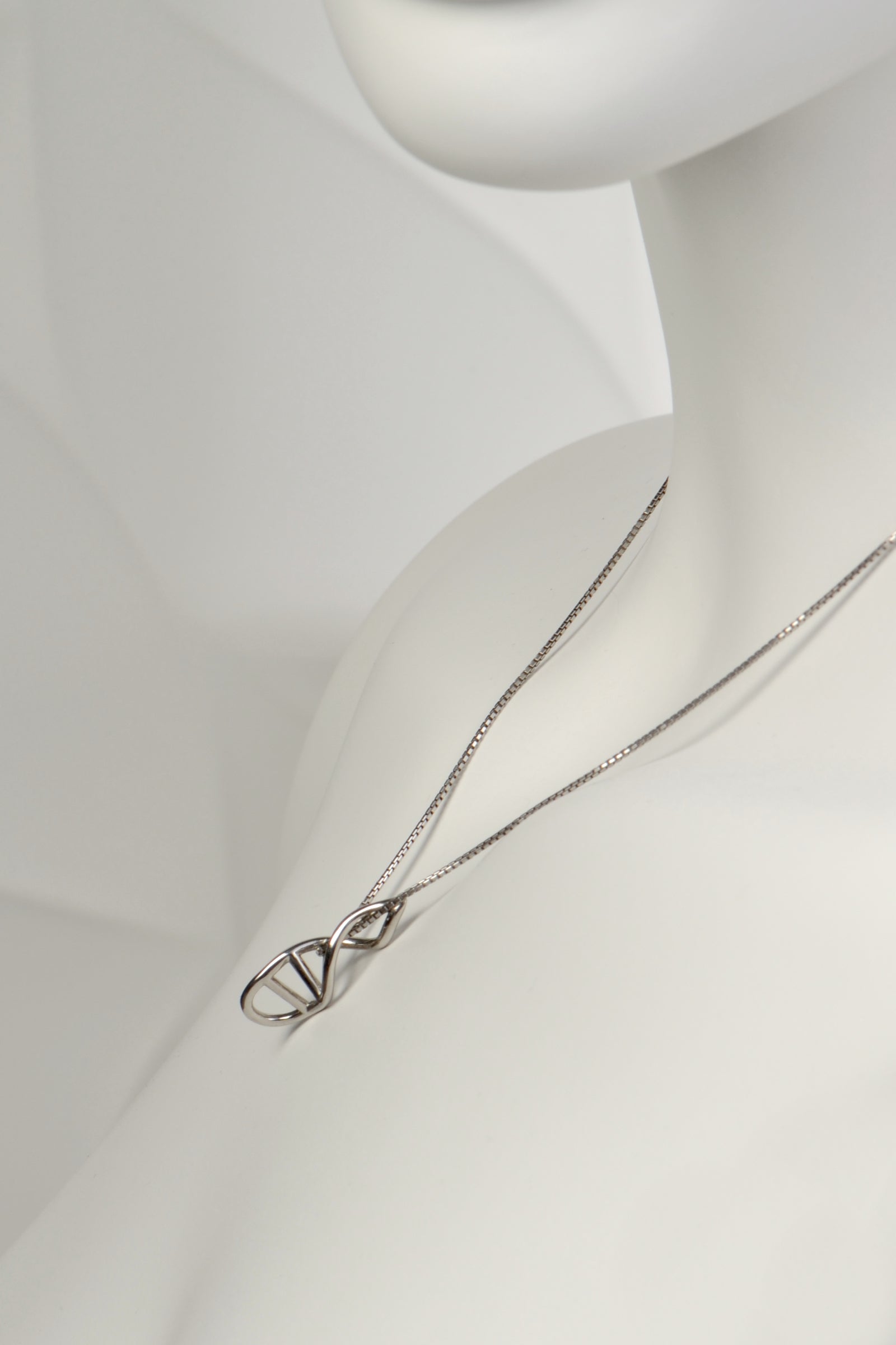 side view of the alternative styling of the silver helix pendant showing that it sits flat and close to the body - Christine Sadler
