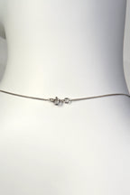 Detailed close-up of a small, discrete 9ct white gold bolt ring clasp on a fine curb chain. Christine Sadler