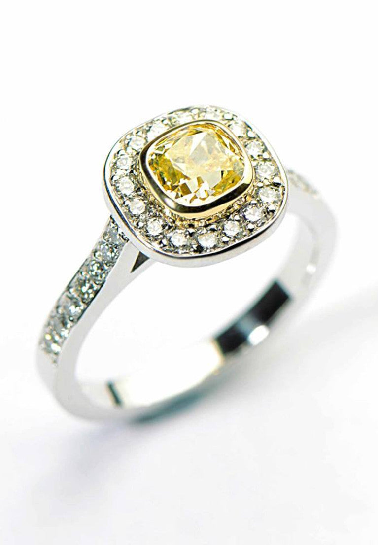 platinum halo ring with a cushion cut yellow diamond set in a yellow gold rubbed over setting and pave with diamonds around the centre stone and diamonds in the band - a bespoke engagement ring from Christine Sadler