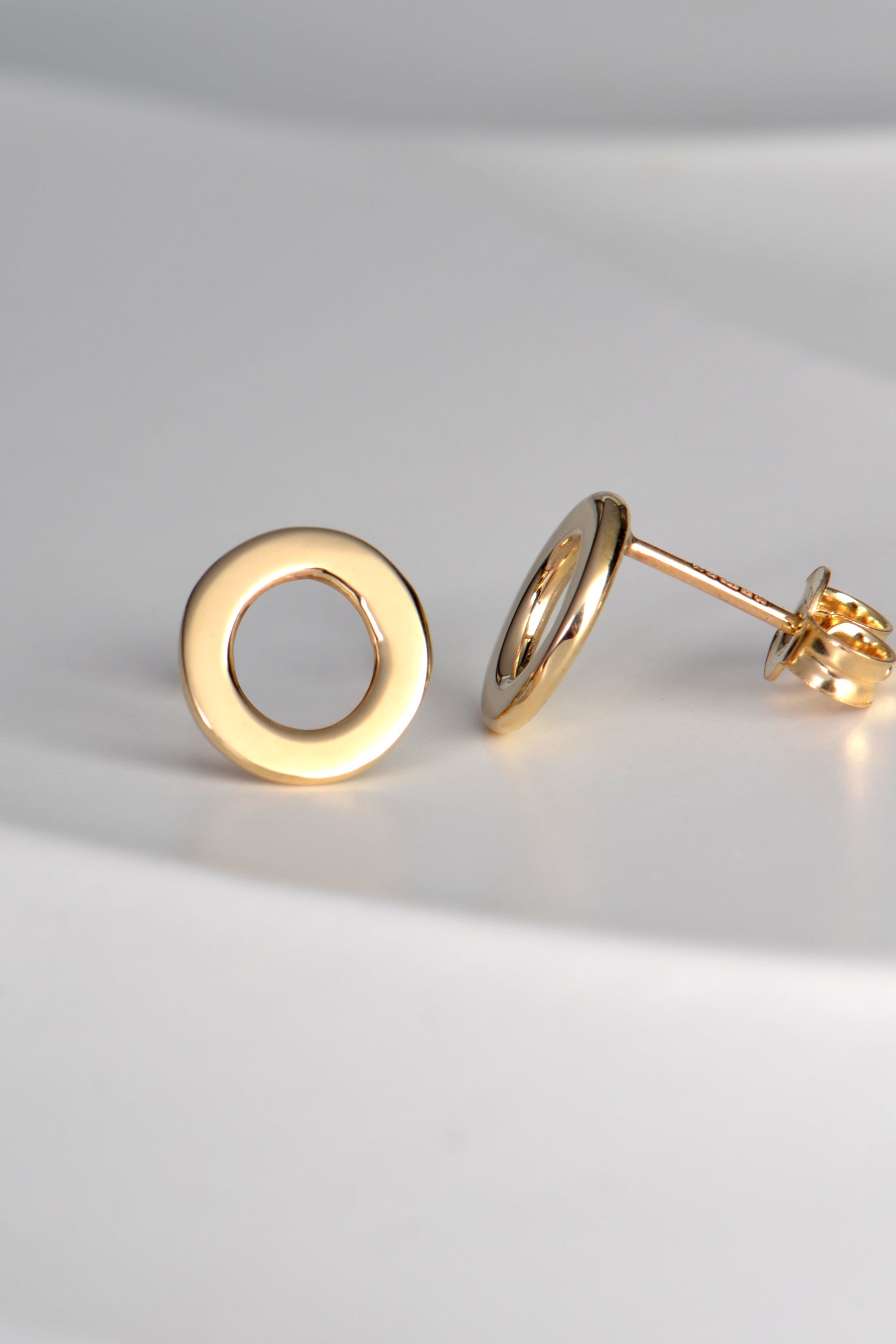 real gold round earrings with the earring post at the top of the ear