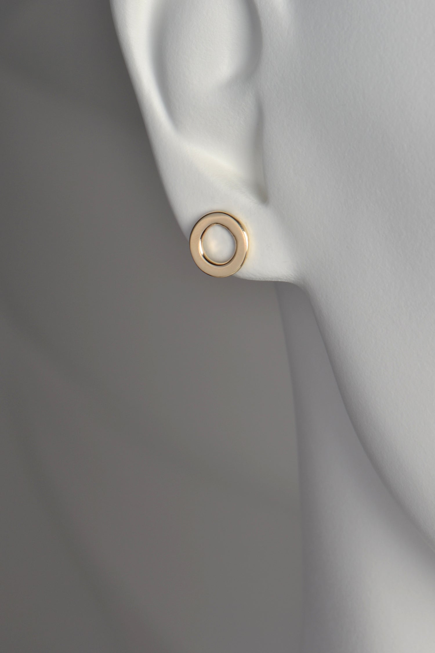 a circle of gold earrings with a space in the middle . They are 10mm in diameter and the bottom of the earring sits just below the earlobe. 