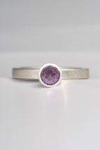 contemporary handmade silver designer ring with an amethyst gemstone. This ring is designed to look like a cupcake. It has a narrow band and can be stacked with other rings if desired.