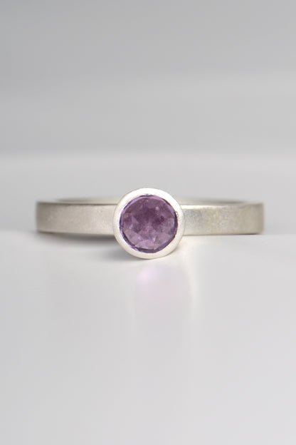 contemporary handmade silver designer ring with an amethyst gemstone. This ring is designed to look like a cupcake. It has a narrow band and can be stacked with other rings if desired.