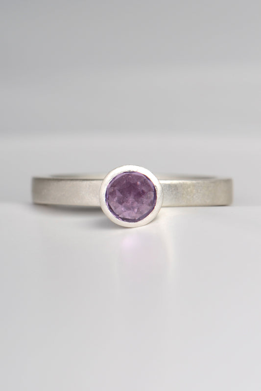 contemporary handmade silver designer ring with an amethyst gemstone. This ring is designed to look like a cupcake. It has a narrow band and can be stacked with other rings if desired.