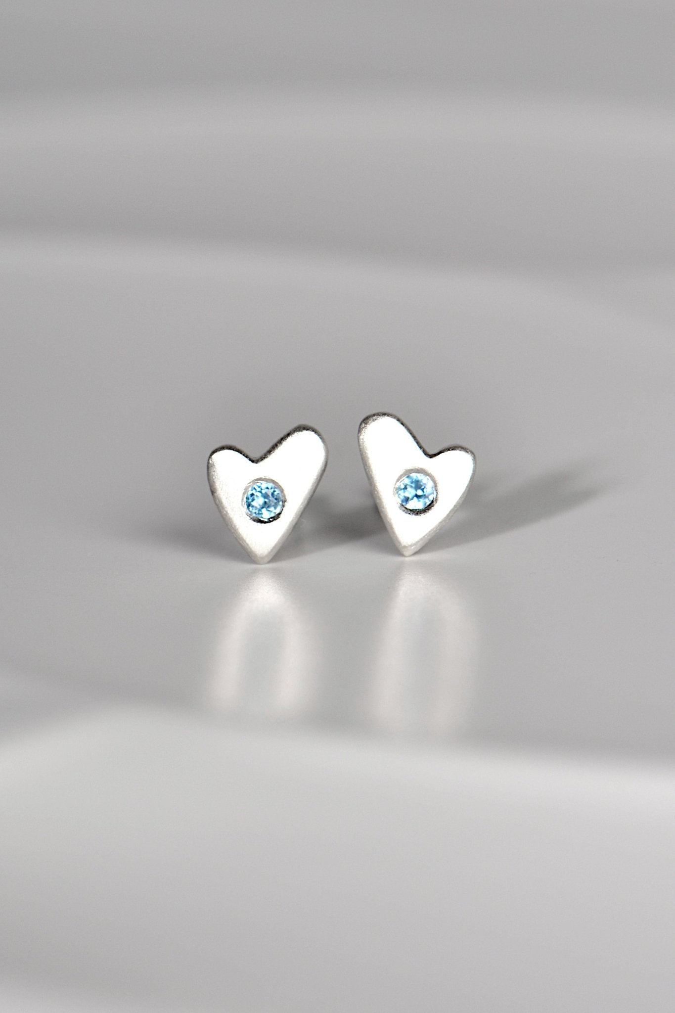 handmade silver heart earring in matt finish set with real aquamarine gemstones - on a white background