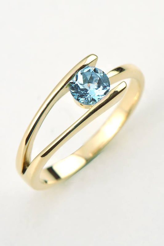 modern yellow gold ring set with an round aquamarine