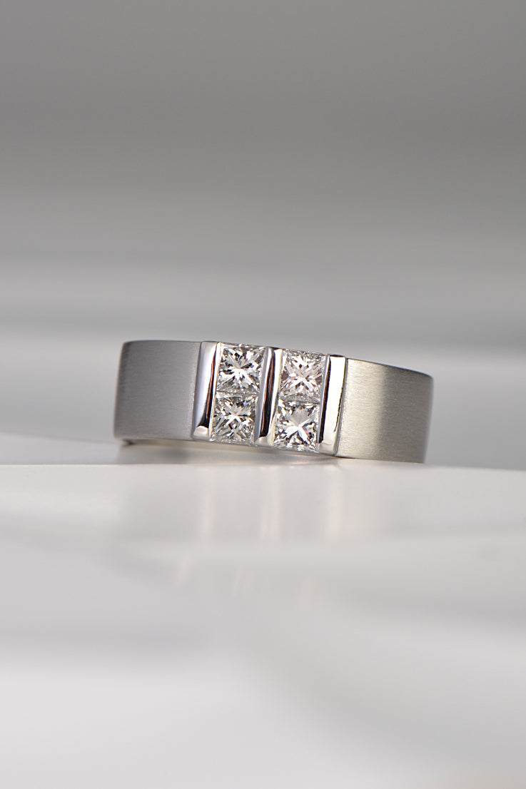 contemporary platinum and diamond princess cut ring inspired by battenberg cake. Four princess cut diamonds are set in a square pattern with polished bars on a wide platinum band.