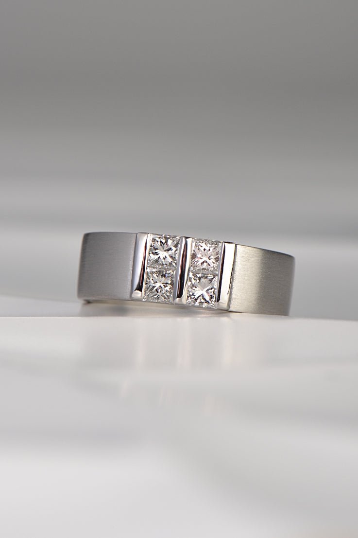 contemporary platinum and diamond princess cut ring inspired by battenberg cake. Four princess cut diamonds are set in a square pattern with polished bars on a wide platinum band. A Highly unusual design available exclusively from Christine Sadler