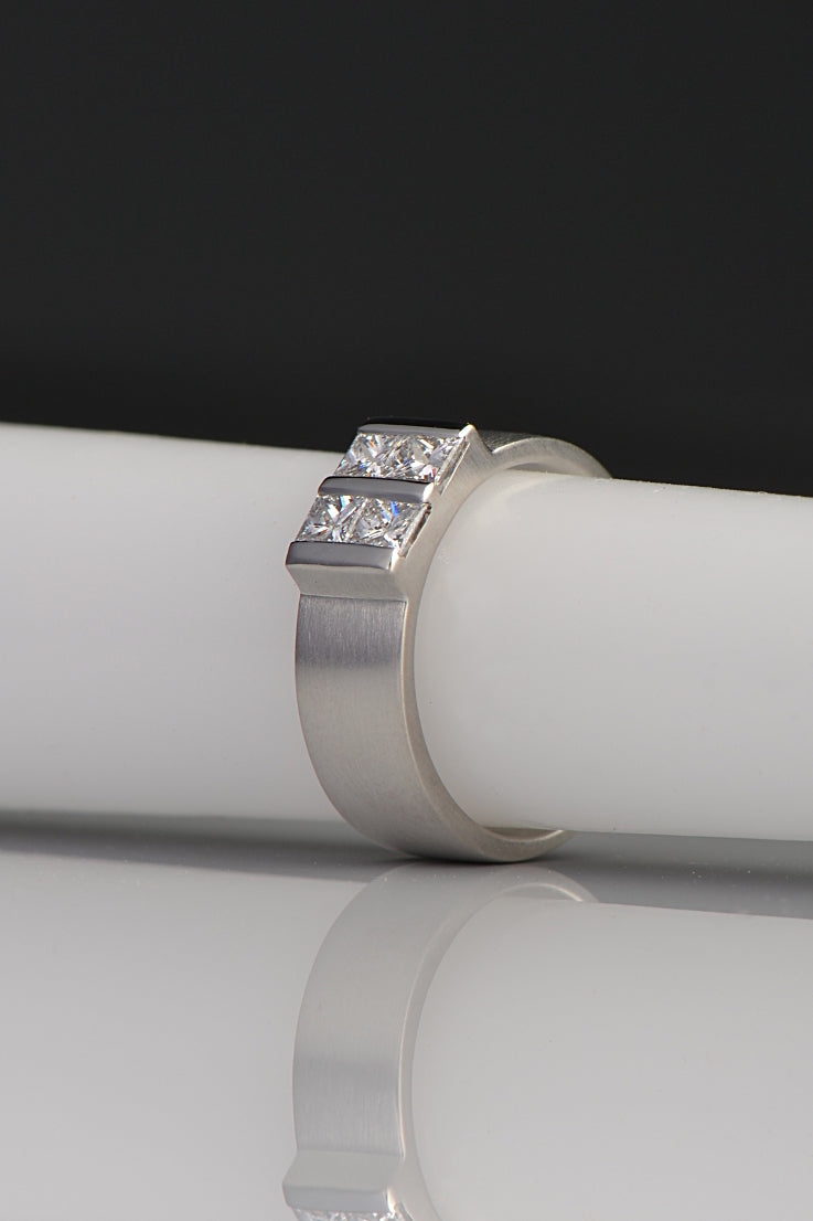 platinum and diamond princess cut ring inspired by battenberg cake. Four smaller diamonds form a large square pattern. The diamonds sit low to the finger on a 6mm wide platinum band