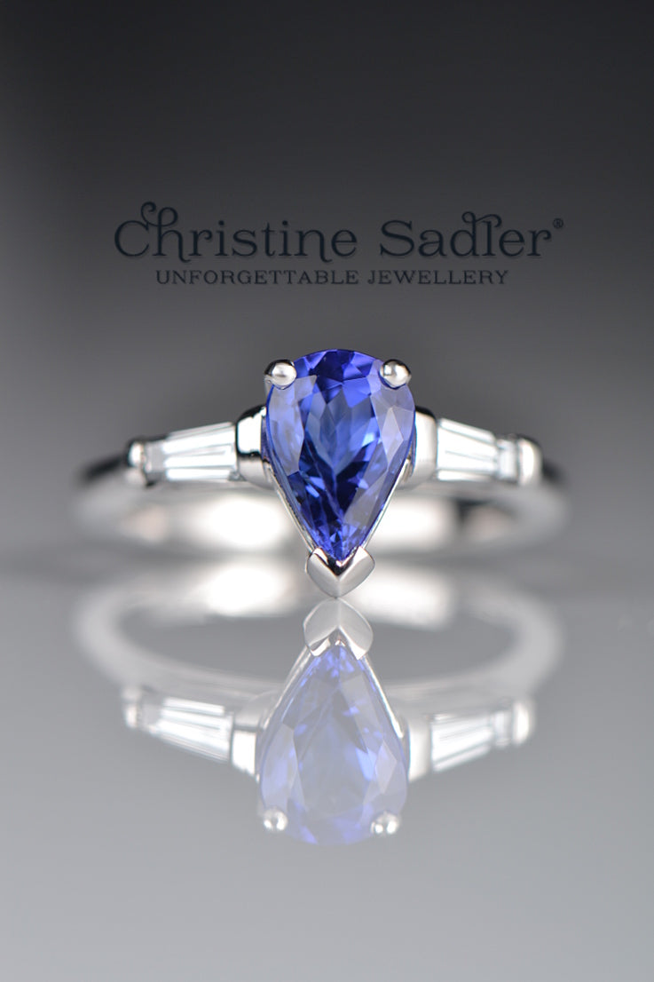 intense blue pear cut tanzanite engagement ring with two tapered baguette diamonds in a contemporary fine jewellery design by scottish designer Christine Sadler