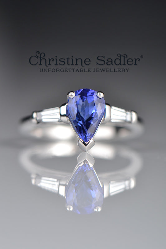 intense blue pear cut tanzanite engagement ring with two tapered baguette diamonds in a contemporary fine jewellery design by scottish designer Christine Sadler